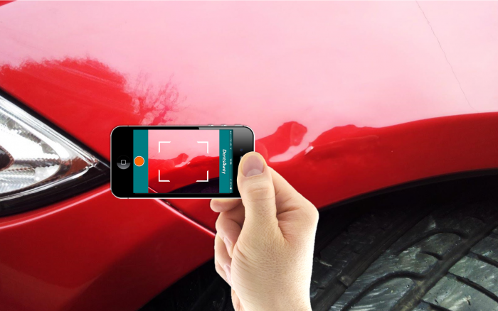 someone taking a picture of a dent on their car
