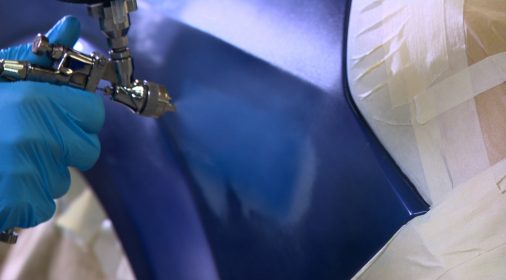 close up of someone spray painting a car