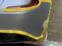 Silver car rear bumper prepped for paintwork repair