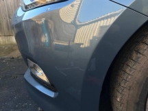 Close up of blue metallic car front bumper