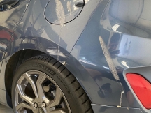 Dirty blue grey car with wheel arch scratch