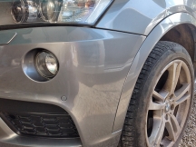 Grey car close up of passenger side from bumper and headlight