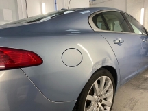 Pale blue car with dent to rear wheel arch
