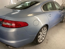 Pale blue car with repaired rear wheel arch