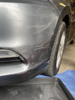 Grey car with scratch on front bumper