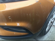 Orange car with scratches on front bumper