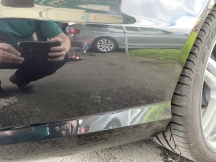 Dusty black car repaired near rear wheel arch