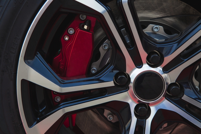 Silver alloy wheel with red brake and black tyre.